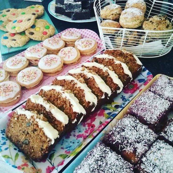 Cookies, iced biscuits, carrot cake and coconut-topped squares on the cake counter